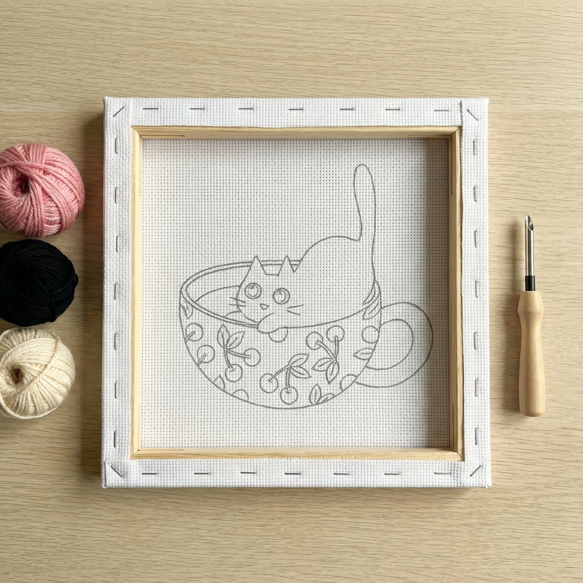 Finished Chaton aux Cerises punch needle artwork styled in a home interior.