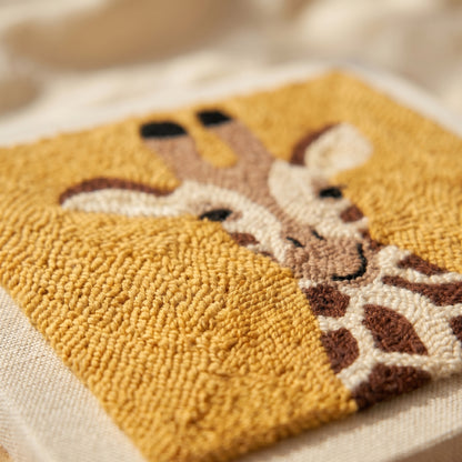 Finished Isabel la Girafe punch needle artwork styled in a home interior.